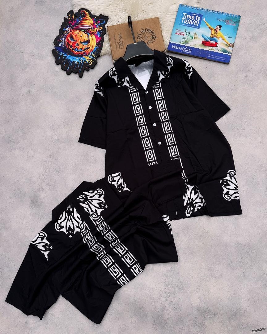 Black shirt and shorts with white Greek pattern displayed with accessories.