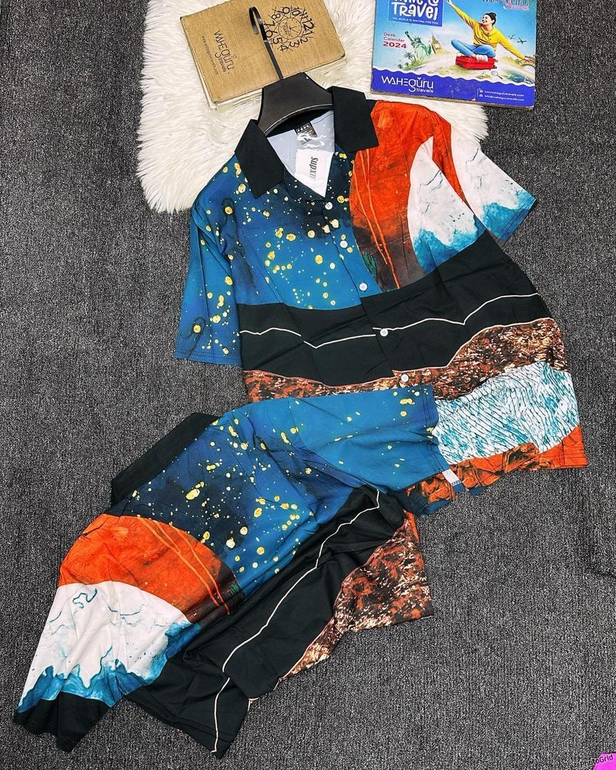 Multi-color abstract pattern shirt and shorts set on dark gray floor.