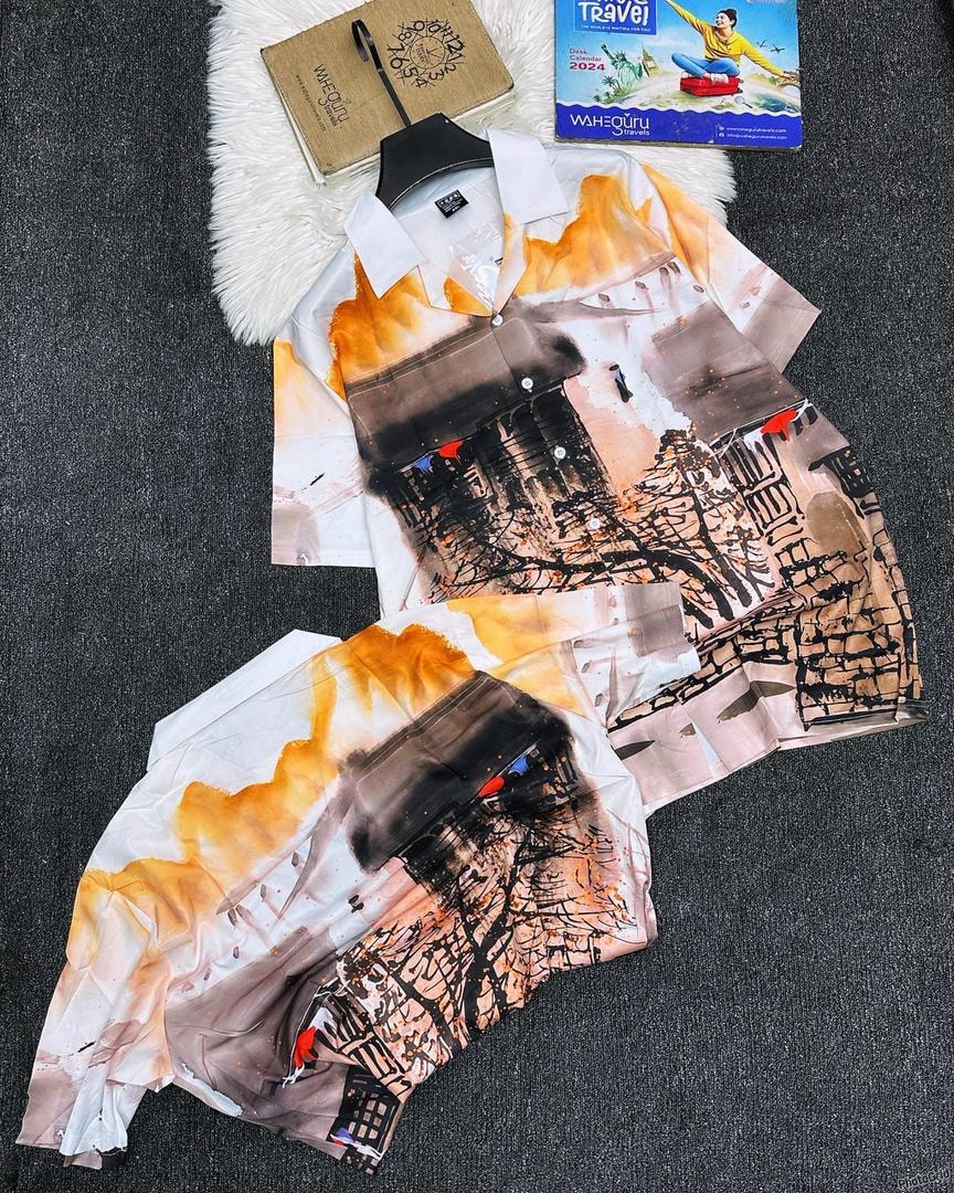 White shirt and shorts with abstract city print displayed on dark surface.