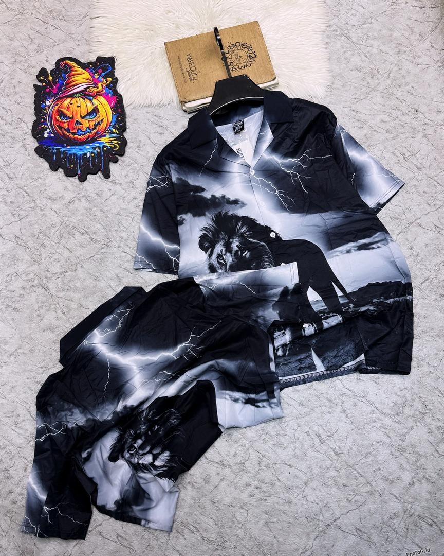 Black and white lion lightning print shirt and shorts set on light surface with decorations.