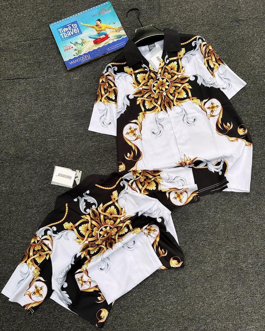 Black white and gold baroque floral print shirt and shorts set displayed on gray floor.