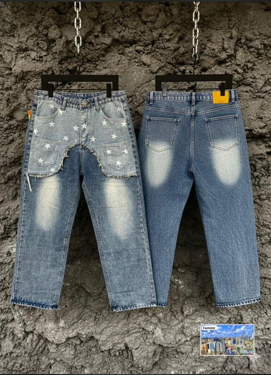 Two pairs of light blue baggy jeans hanging, one with star prints and cutouts, the other with faded back details.