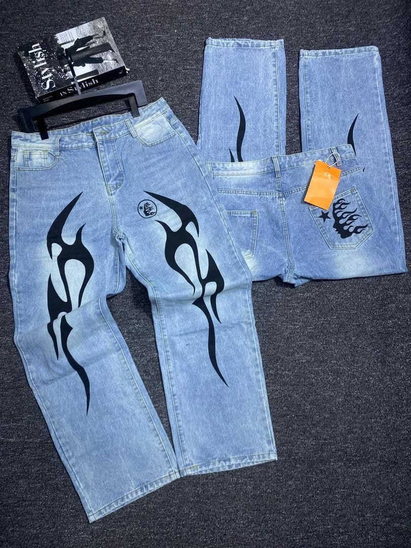 Flat lay and details of light blue jeans with large black flame and tribal prints.