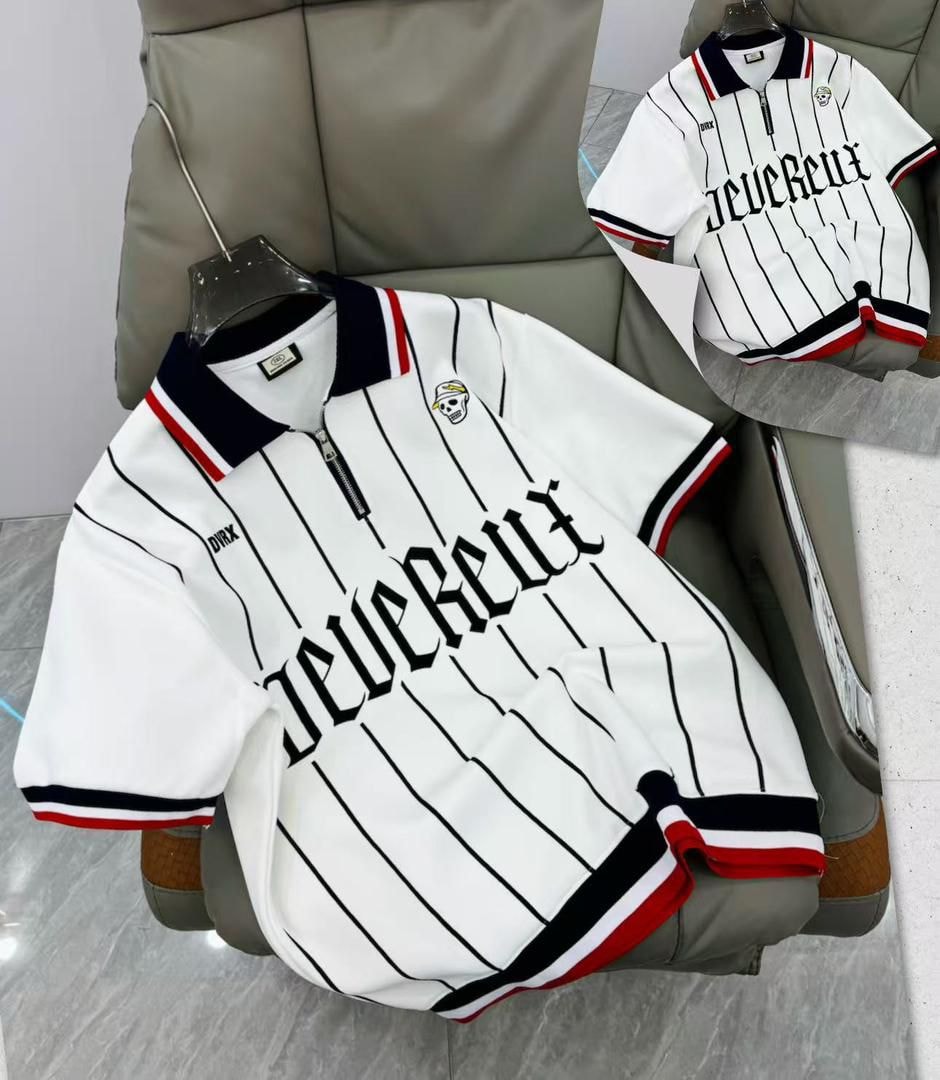 White striped polo shirt with zip collar, skull logo, and striped trims displayed on a chair.