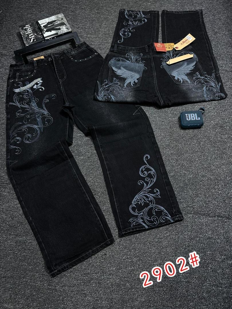 Black baggy jeans with white embroidery of wings and swirls on back pockets and legs.