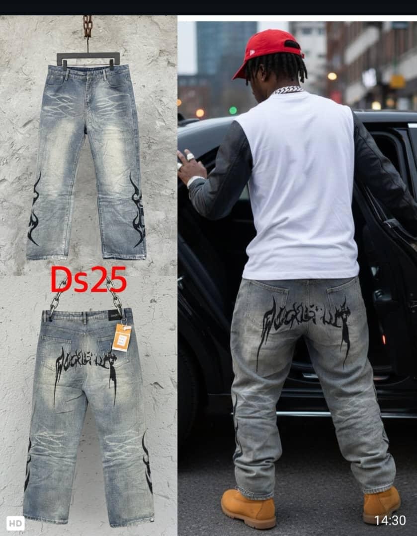 Light wash baggy jeans with black flame designs on legs and graphic text on back, shown in flat lay and lifestyle views.