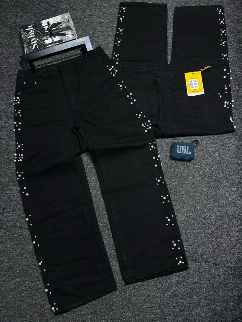 Black baggy jeans with white pearls along side seams, shown in flat lay with front and back views.
