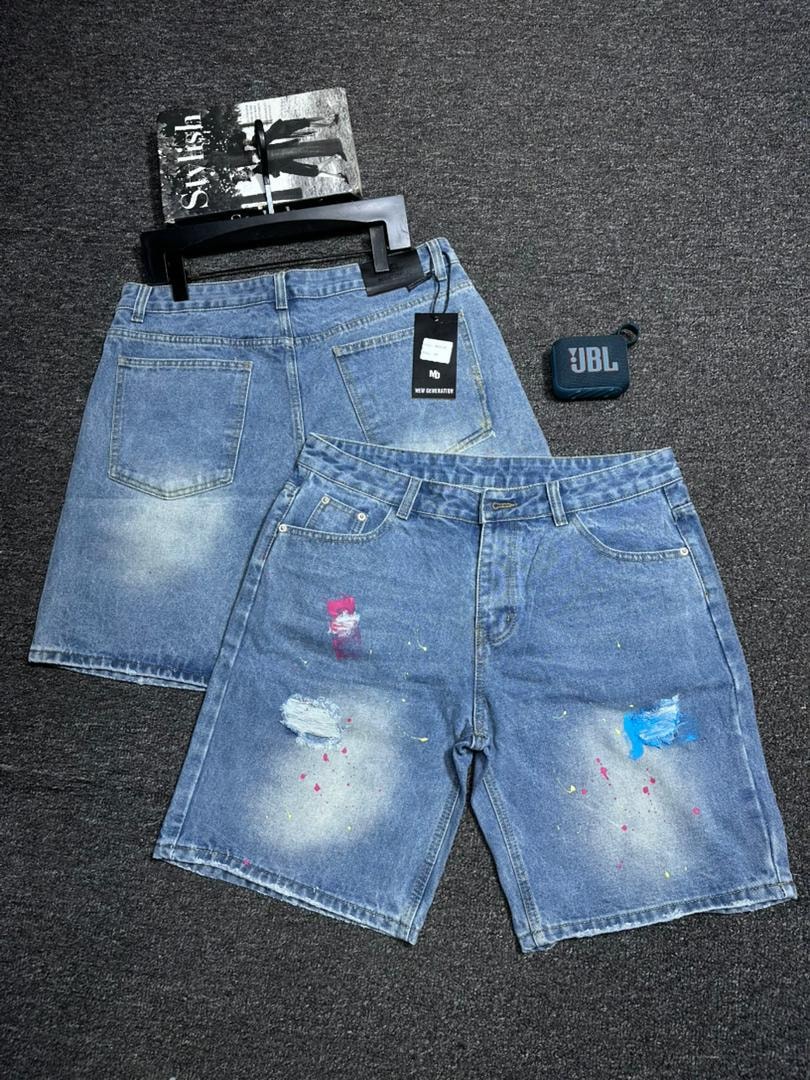 Light blue baggy denim shorts with paint splatter effects and rips displayed with back view.