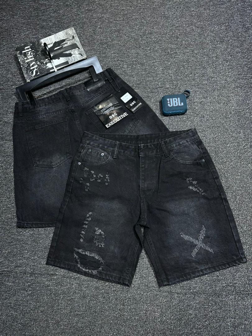 Distressed black baggy denim shorts with white graphic patterns and rips shown flat with accessories.