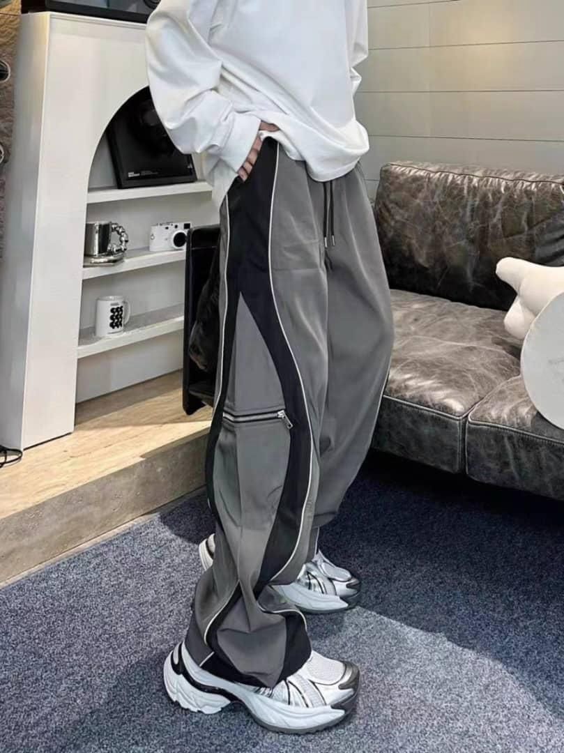 Model wearing gray colorblock joggers with white top and chunky sneakers.