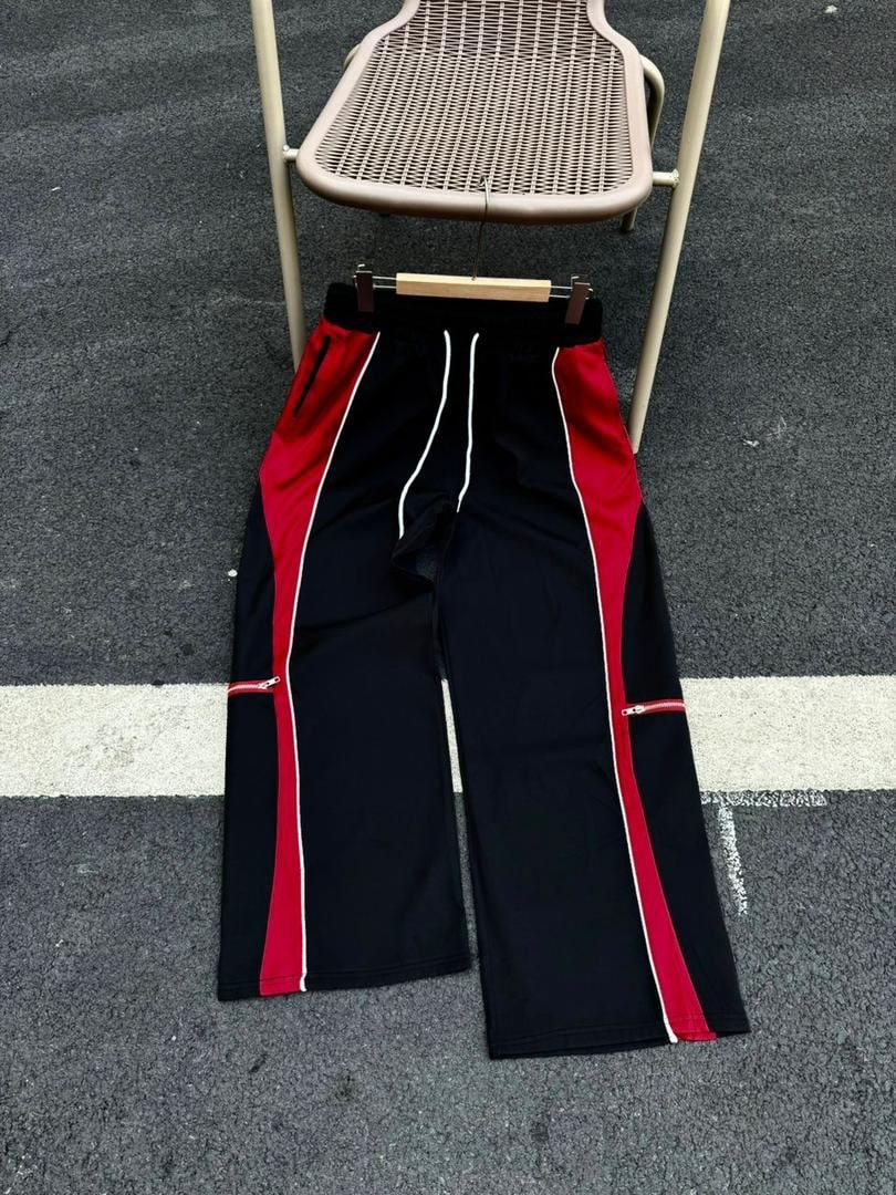 Black joggers with red side panels, white piping and drawstring.