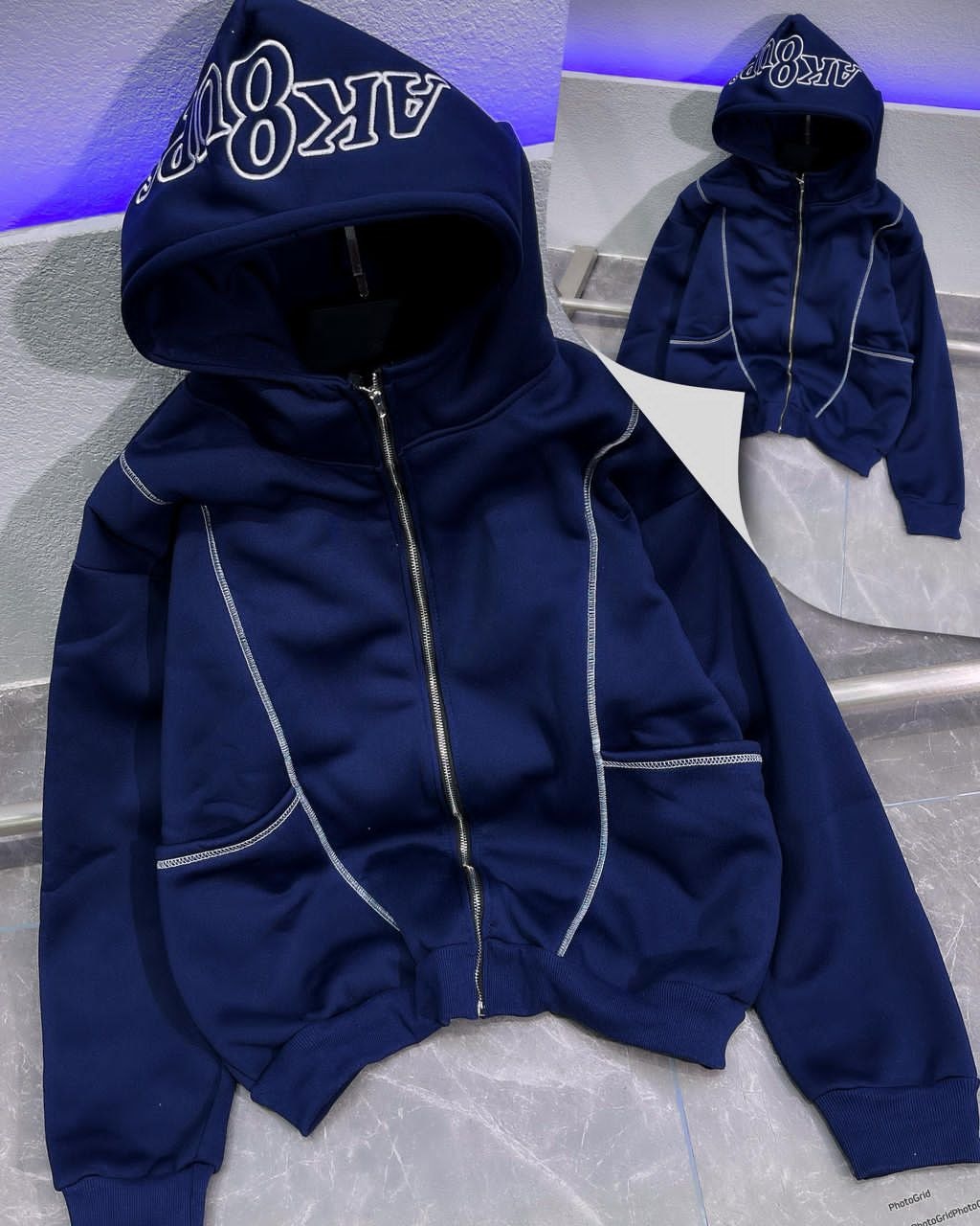 Navy zip-up hoodie with white embroidered hood and contrast stitching.