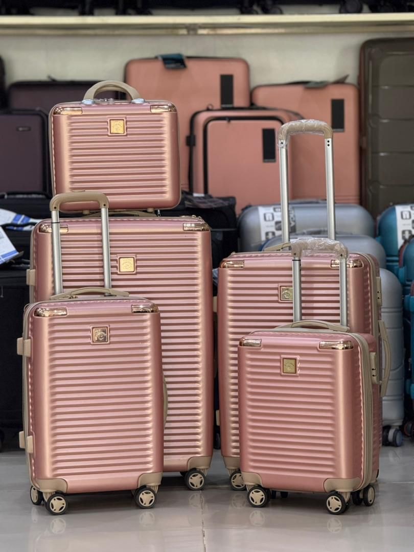 Rose gold 4-piece hardshell luggage set showing all four suitcase sizes with ribbed texture and wheels.