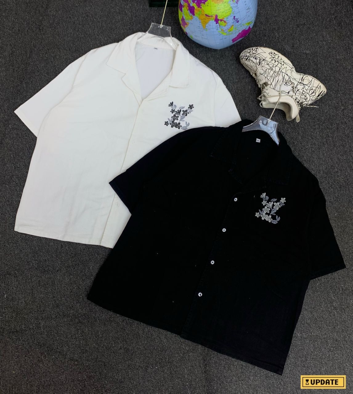 White and black short sleeve shirts with matching floral embroidery on chest.