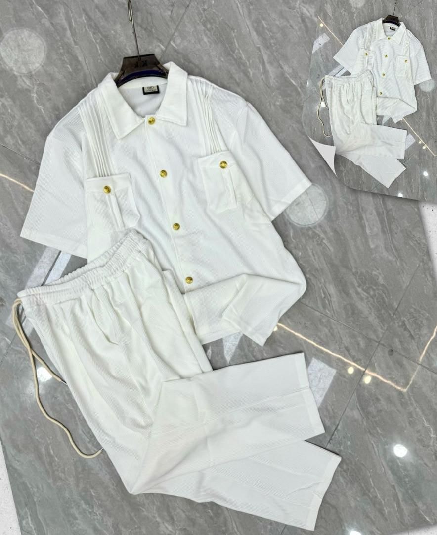 White pleated button-up shirt and pants two-piece set with gold buttons.