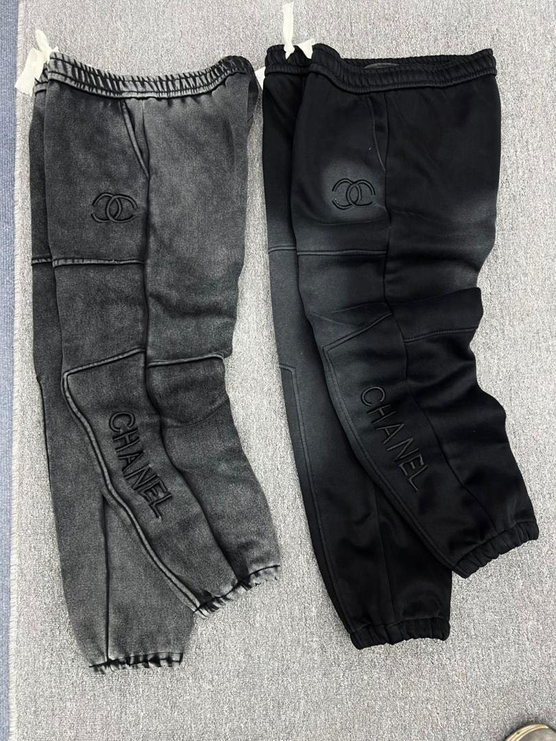 CHANEL embroidered joggers in black and gray shown side by side.