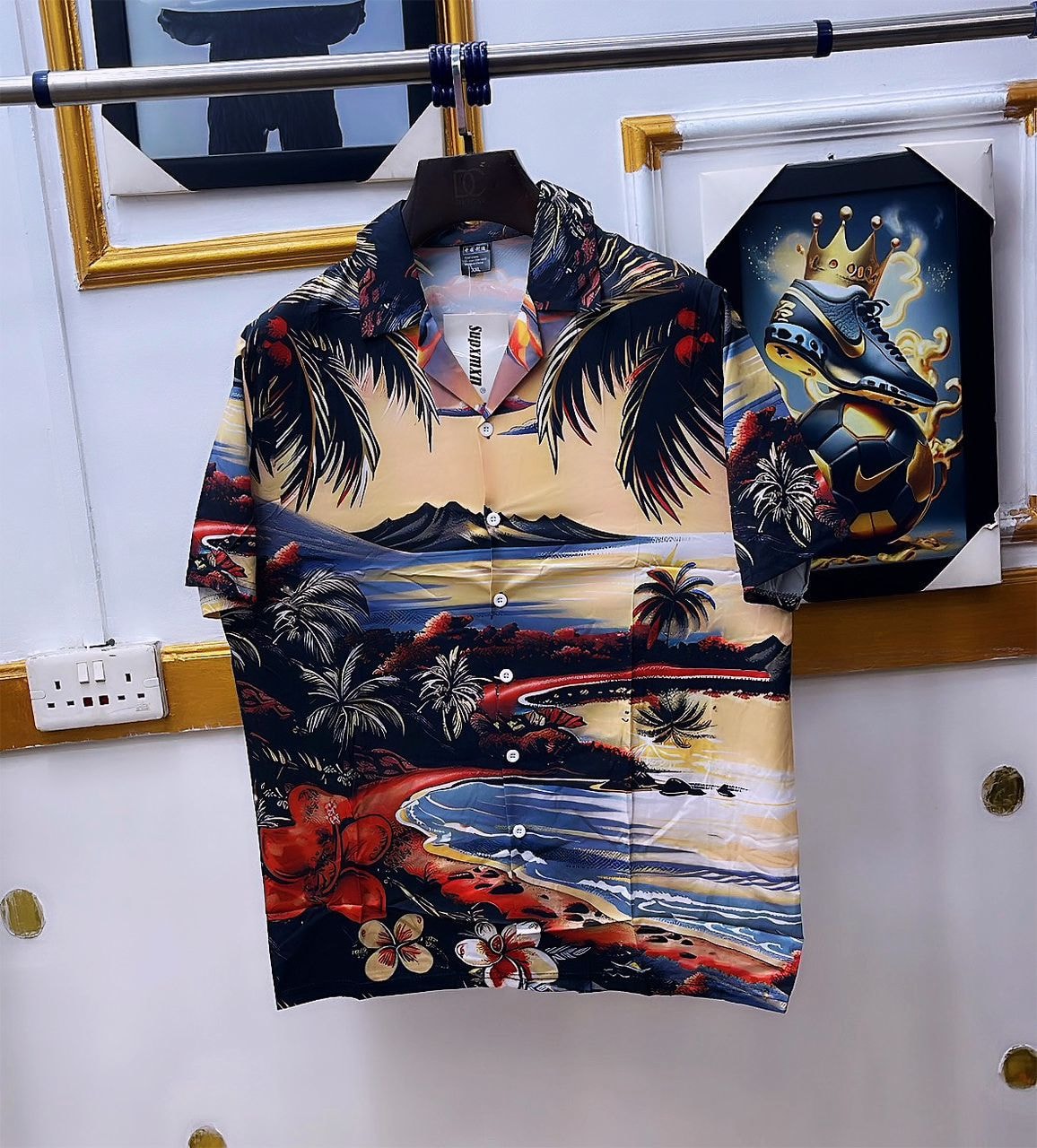 Multi-color tropical landscape print short sleeve shirt hanging on rack.