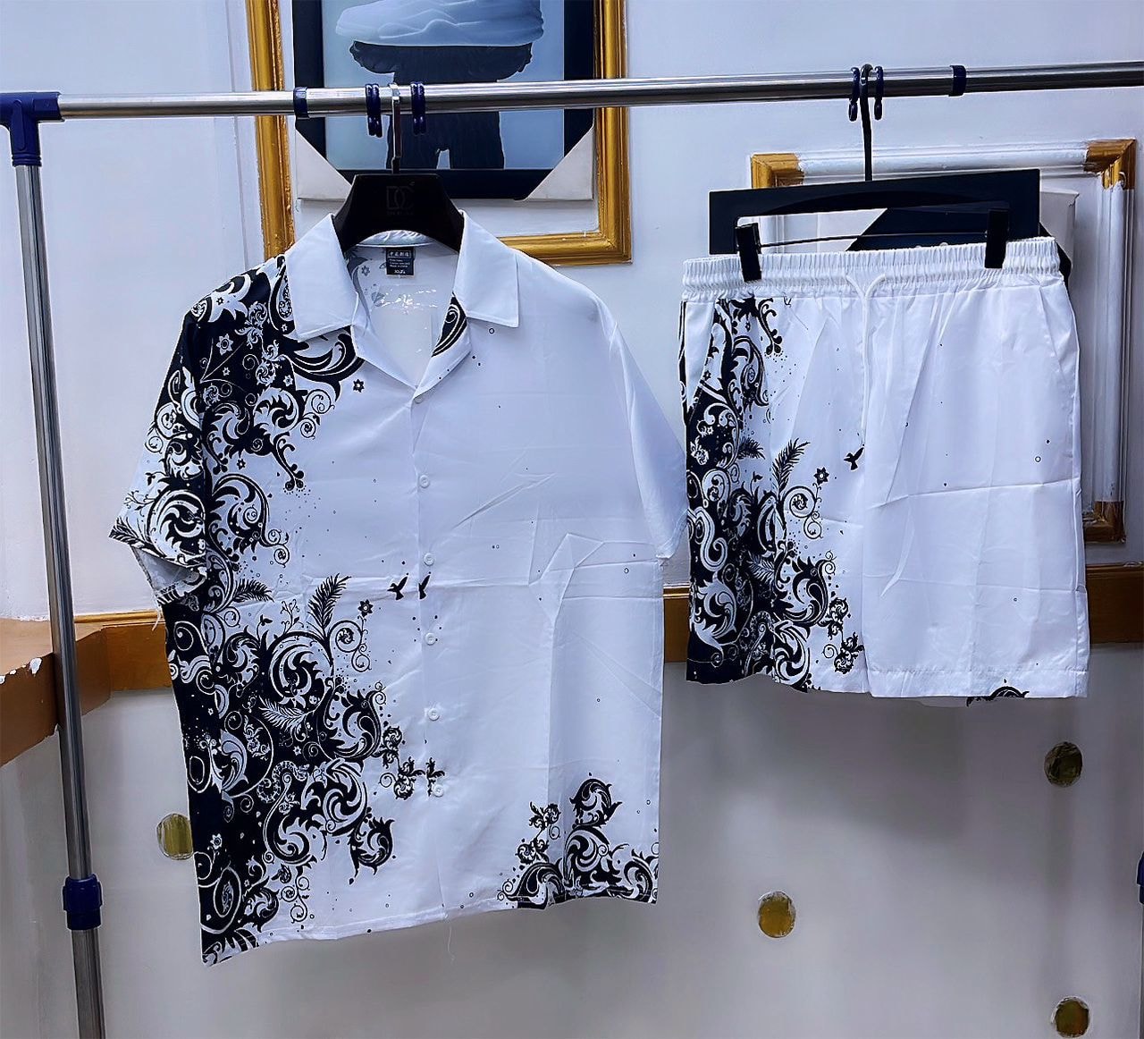 White shirt and shorts set with black ornate scroll and floral pattern.
