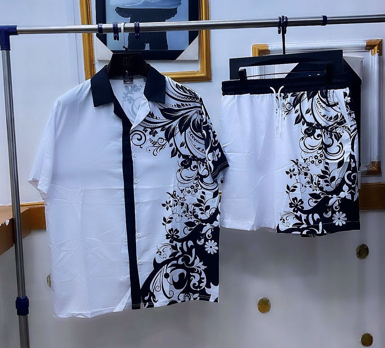 White shirt and shorts set with black paisley floral print on one side.