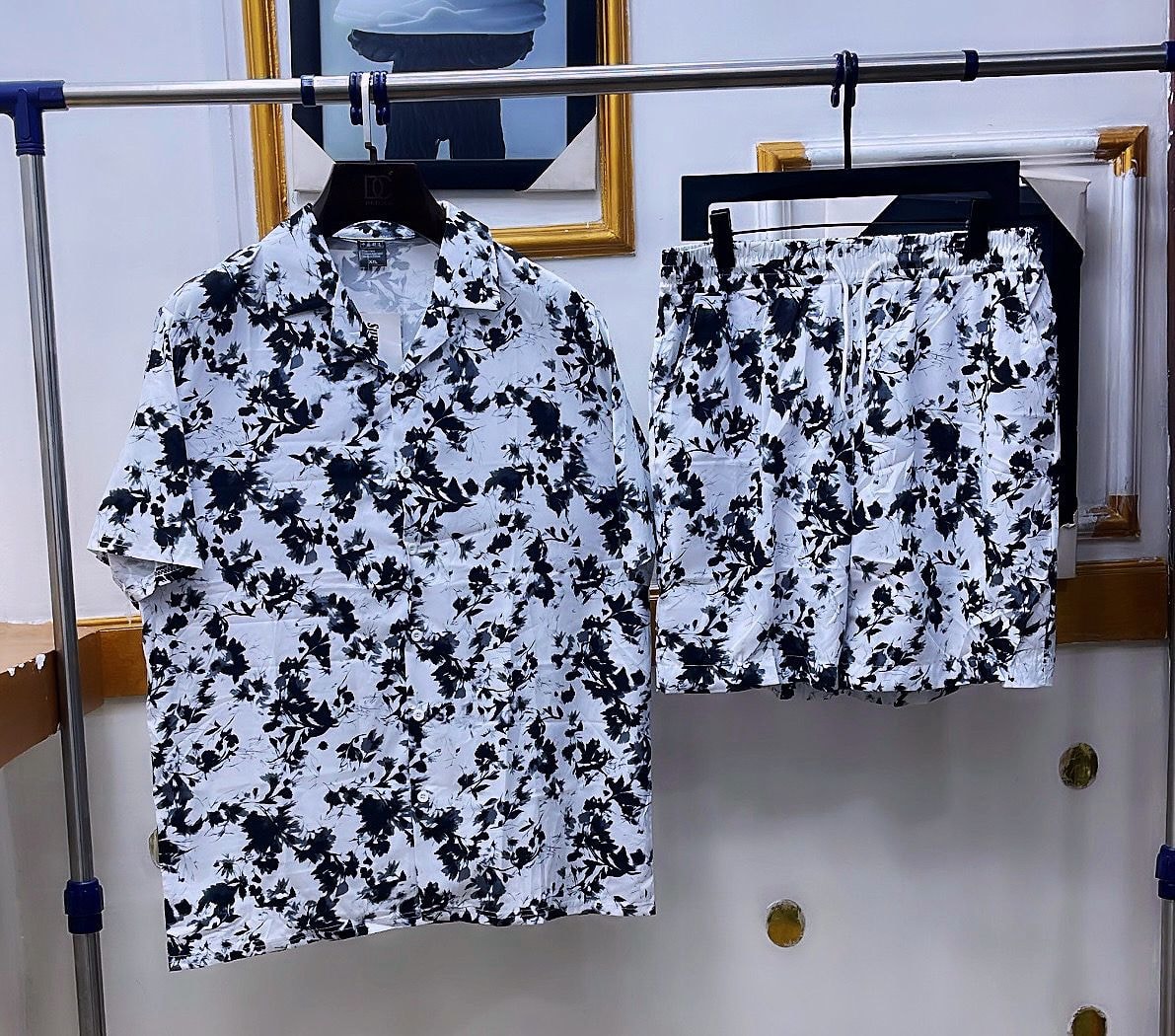 White shirt and shorts set with black all-over floral leaf print.