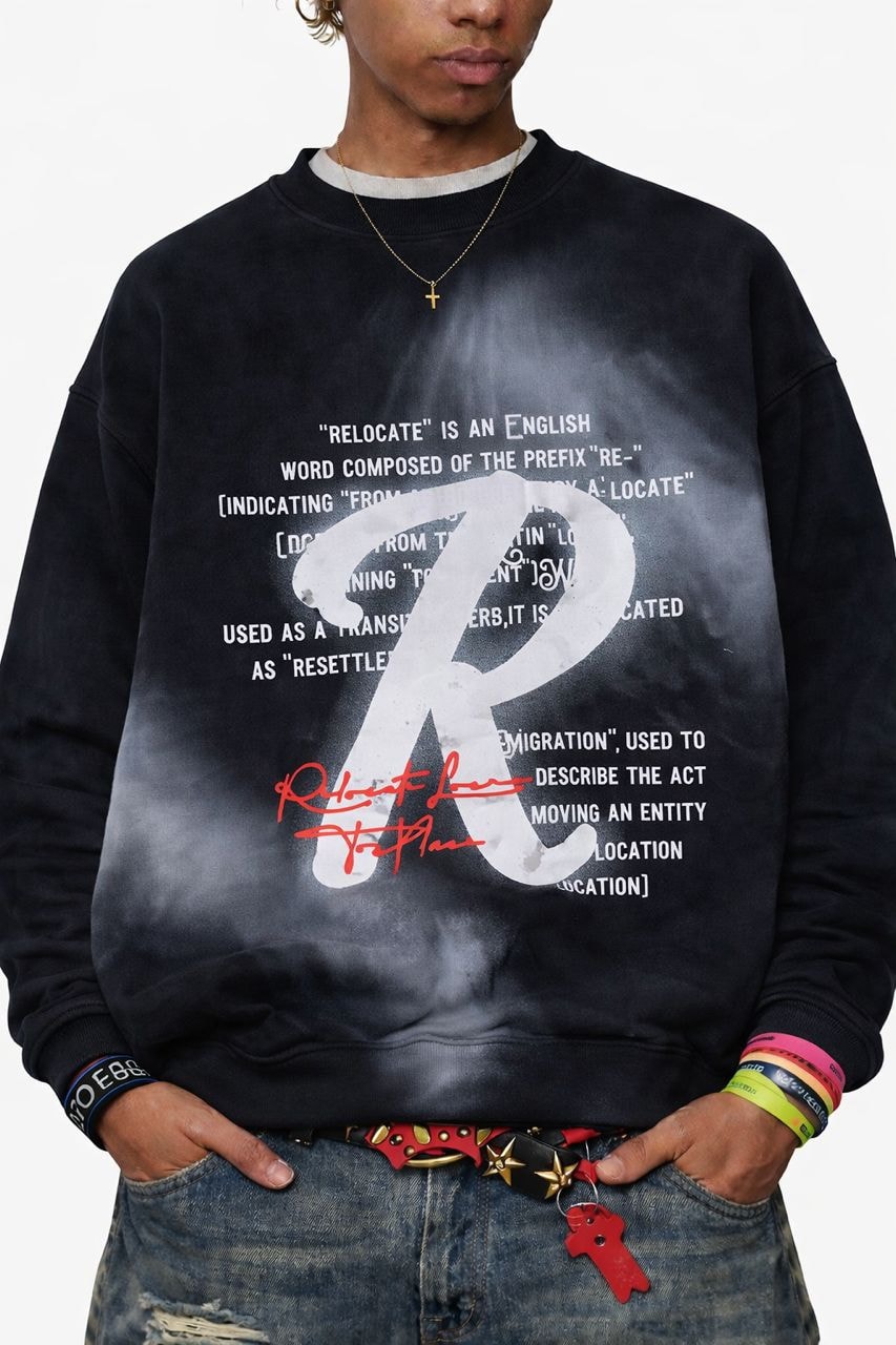Model wearing black bleached relocate graphic sweatshirt with white R design.