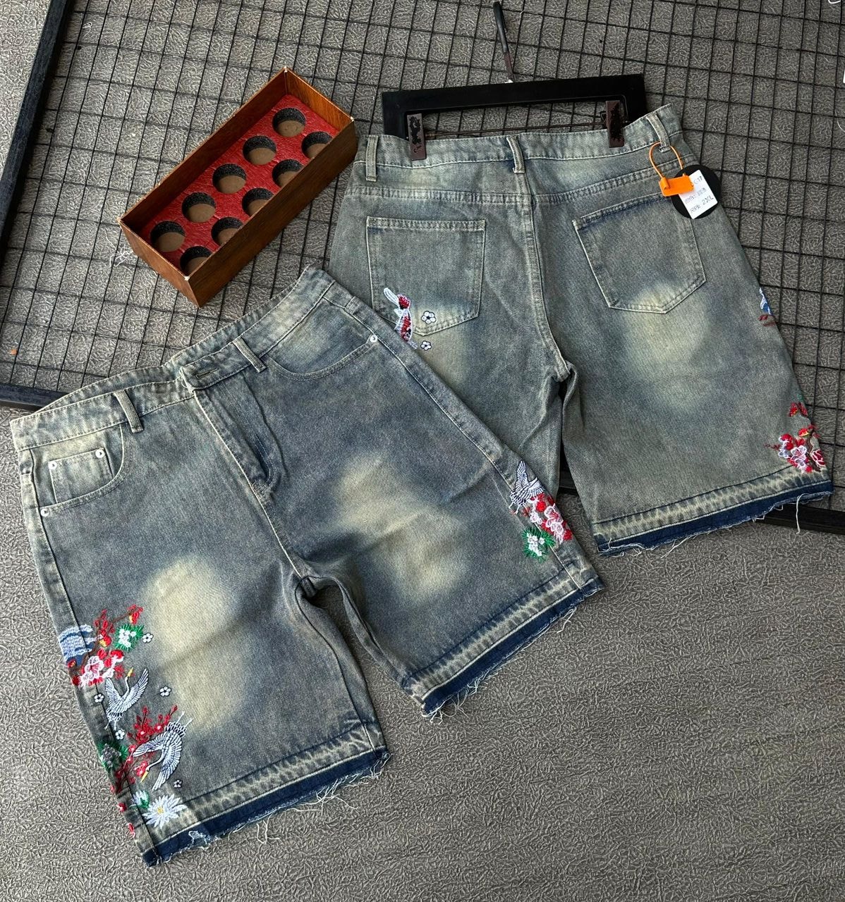 Faded gray denim shorts with colorful bird and floral embroidery shown from multiple angles with accessories.