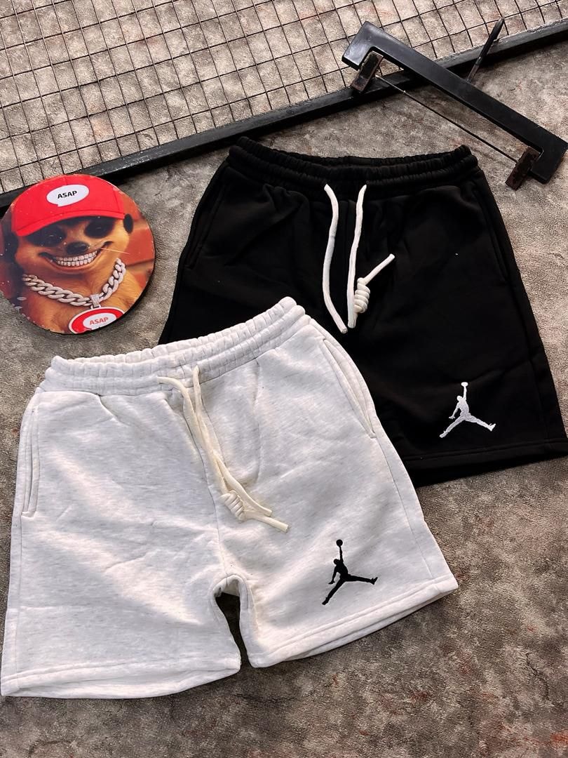 Black and white jogger shorts with Jumpman logos beside circular graphic.