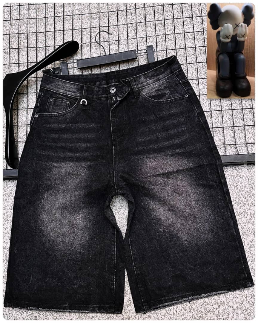 Front view of black washed denim shorts displayed on hanger with accessories.