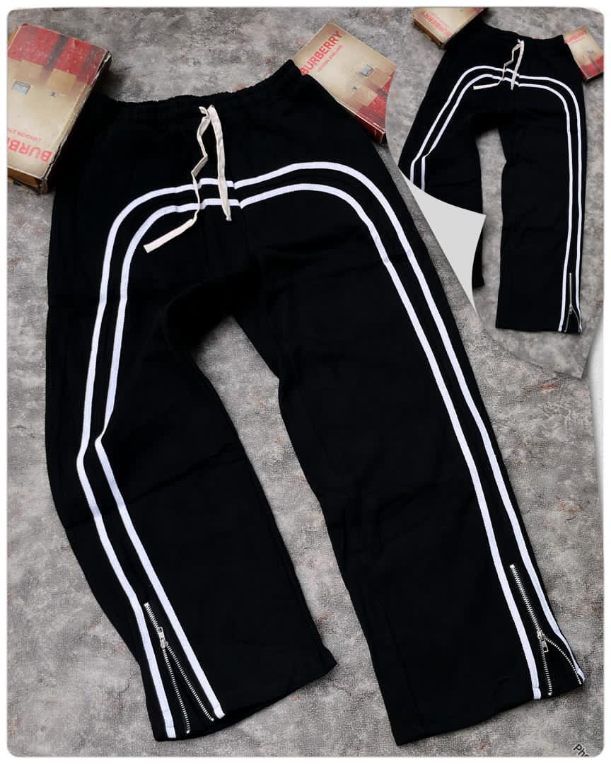 Black curved stripe joggers with white stripes and hem zippers.