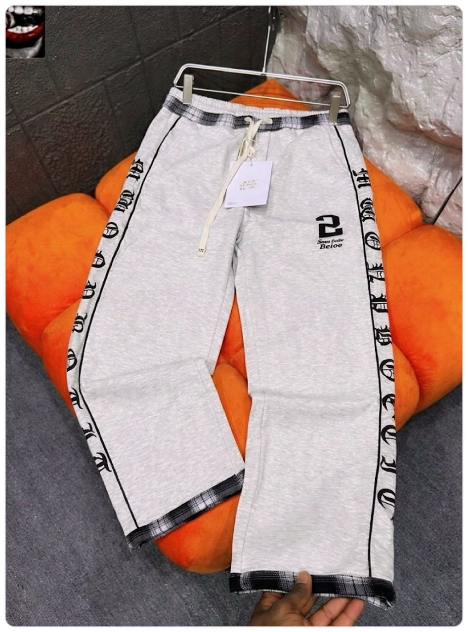 Gray joggers with black side prints, logo on thigh, and plaid cuffs.