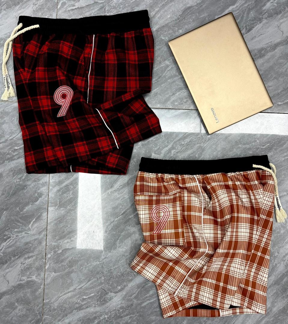 Red and black plaid shorts with 9 logo above brown plaid shorts with 9 logo.
