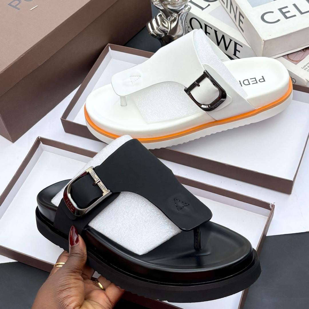White and black PEDRO thong buckle platform slides in boxes with branding visible.