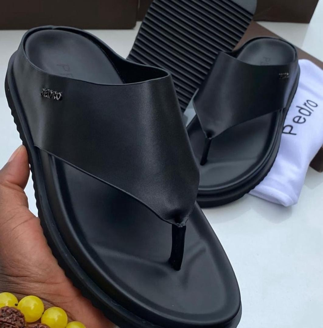 Black Pedro platform thong sandal held showing side view and branding.