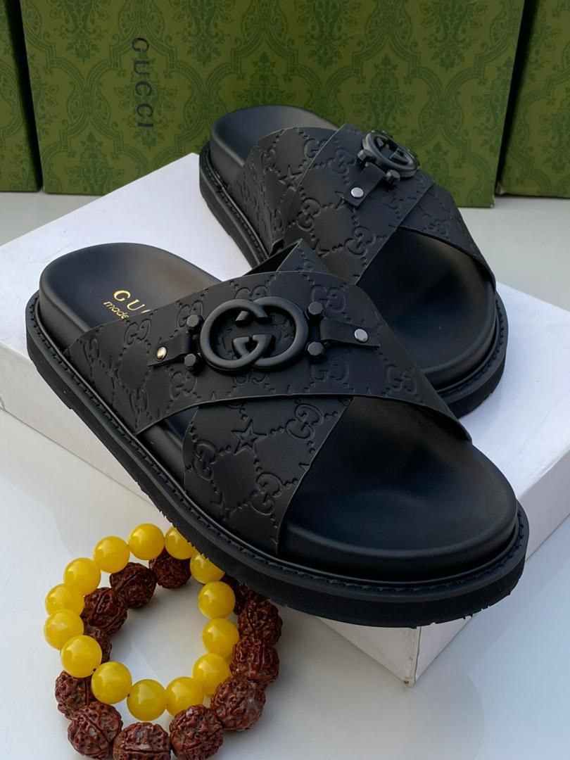 Black Gucci monogram slides with GG embossed pattern and interlocking G logo.
