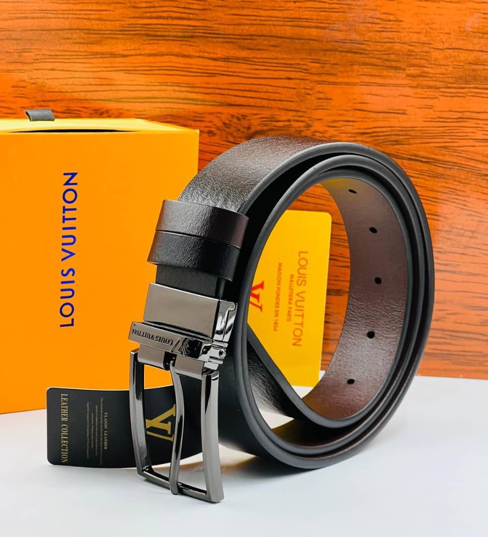 Black leather Louis Vuitton belt with silver buckle shown with yellow branded box and black tag on wooden background.