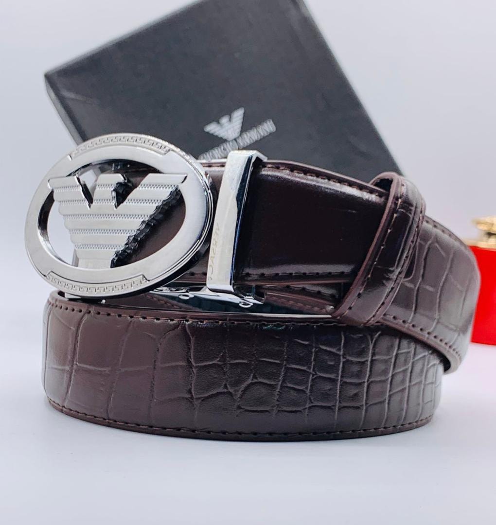 Brown crocodile-pattern leather Giorgio Armani belt with large silver eagle buckle and branded box in background.