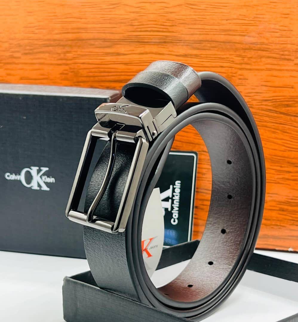 Close-up side view of Calvin Klein black leather belt highlighting the silver buckle engraving and textured leather.