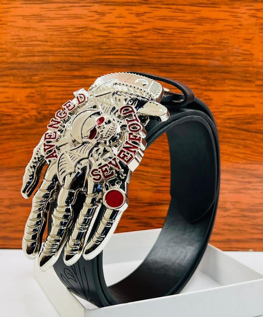 Close-up of silver Avenged Sevenfold skeleton hand belt with red crystal eyes.