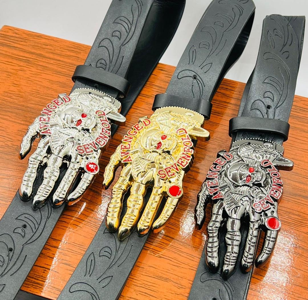Three Avenged Sevenfold skeleton hand belts showing silver and gold buckle variations.