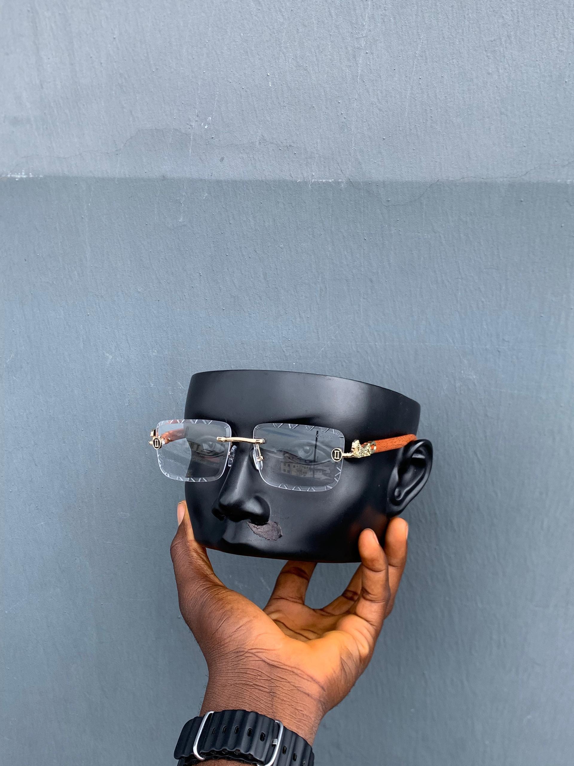 Cartier square rimless sunglasses with clear lenses and brown arm on mannequin.