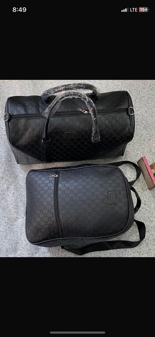 Black Gucci GG monogram duffel bag and backpack set on textured surface.