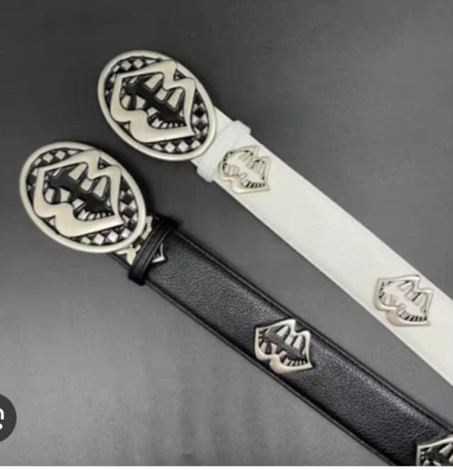 Black and white leather belts with large oval silver crest buckles and repeating emblems shown together.