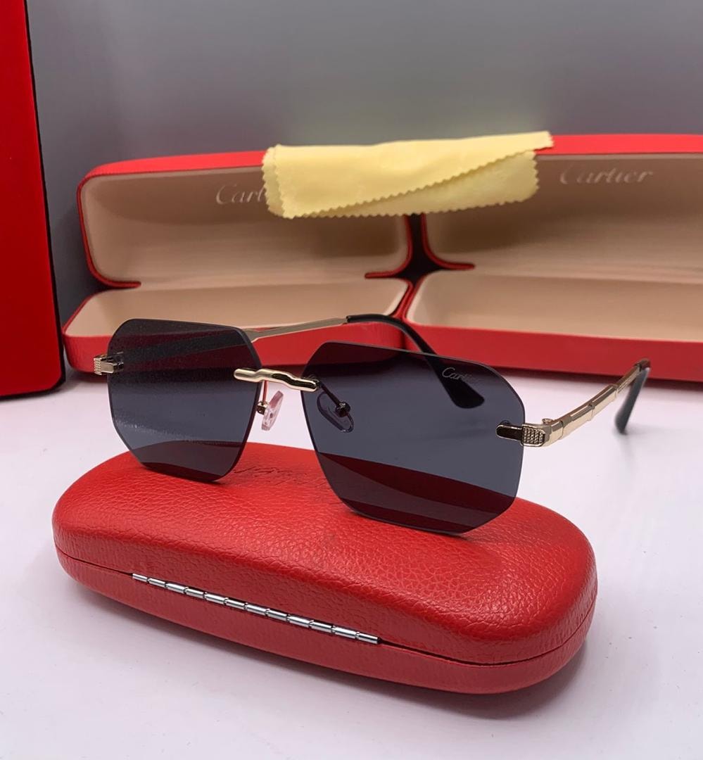 Cartier square sunglasses with dark lenses and gold black frame on red case.