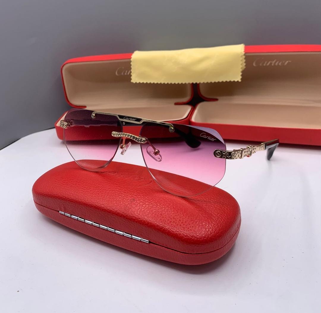 Cartier rimless sunglasses with pink gradient lenses on red case.