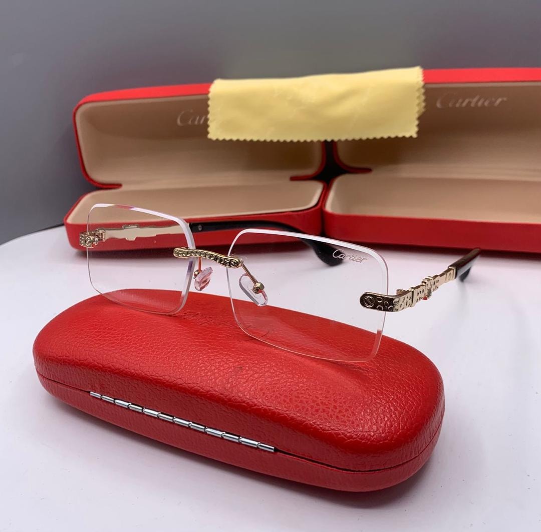 Cartier rimless eyeglasses with clear lenses and gold metal details on red case.