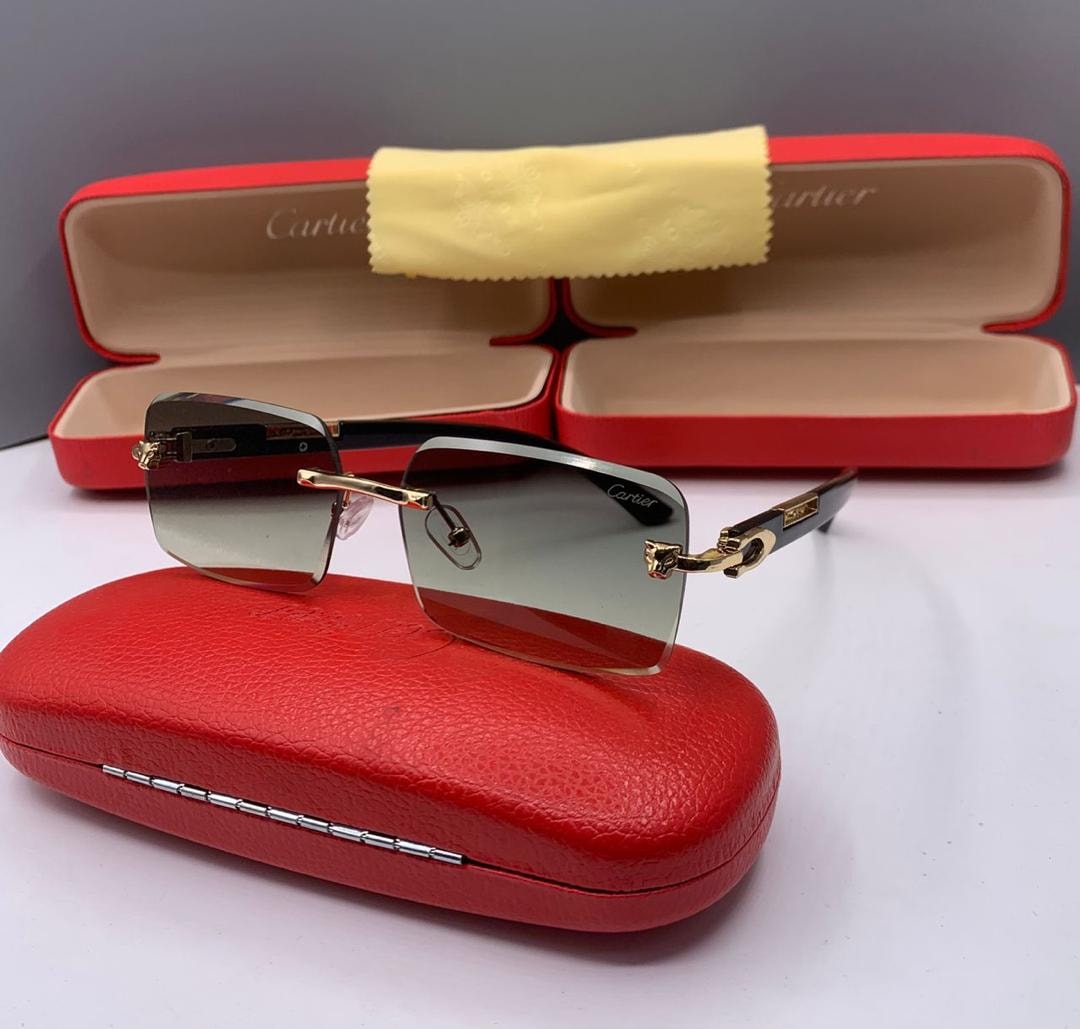 Cartier rimless glasses with gray gradient lenses resting on red case.