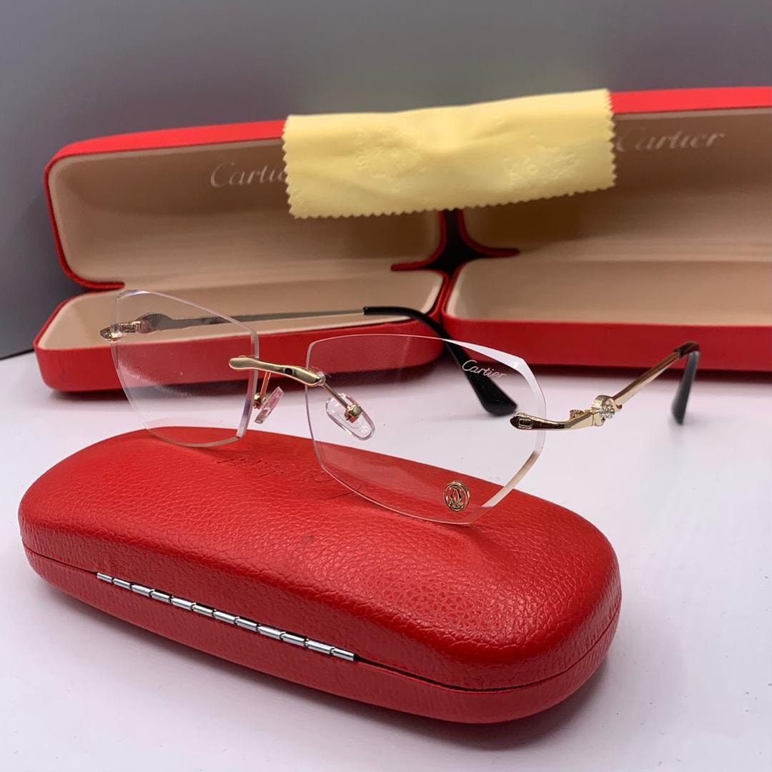 Cartier rimless glasses with clear lenses shown at angle with red case in background.