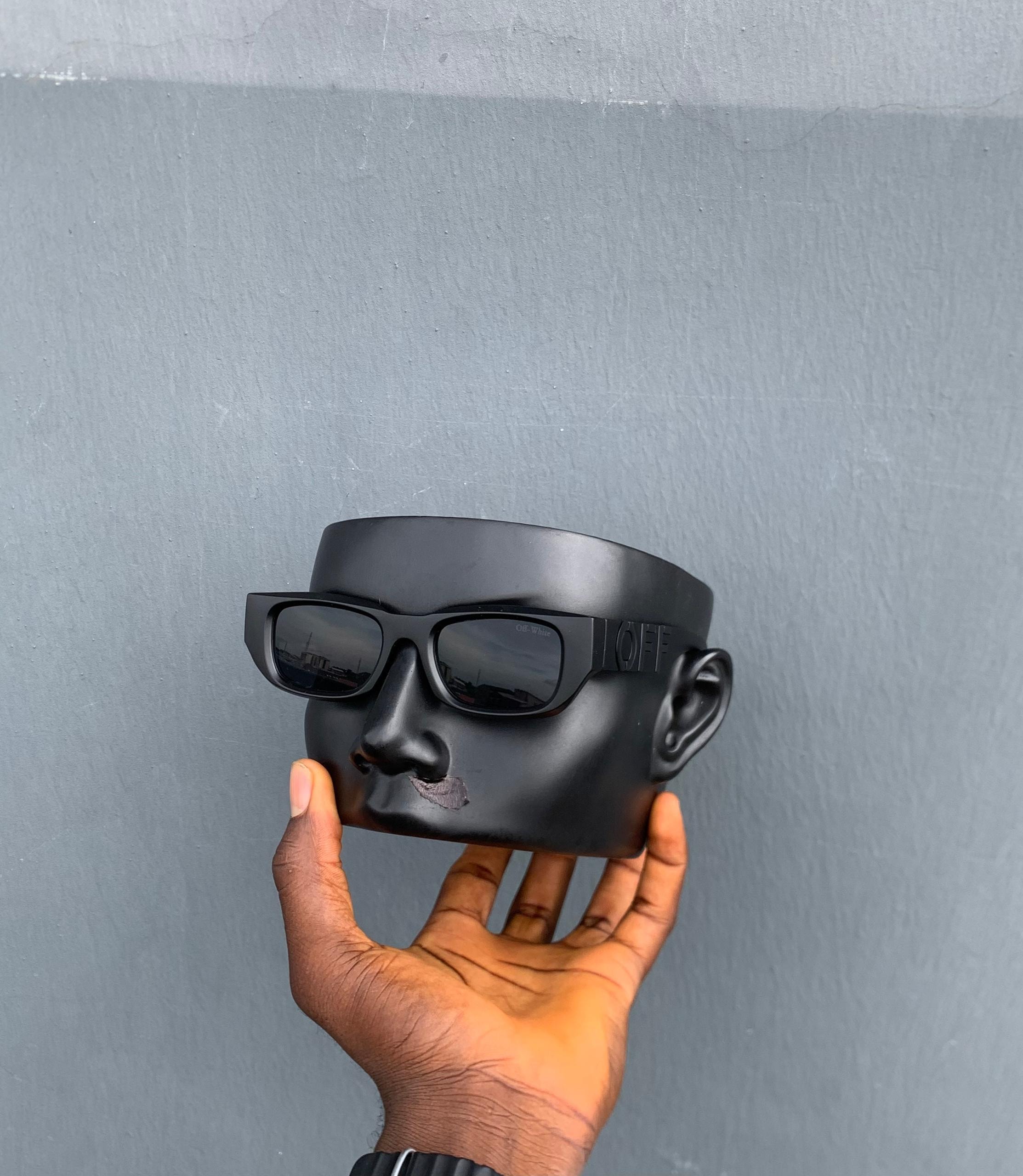 Off-White black sunglasses shown from front angle on mannequin head.