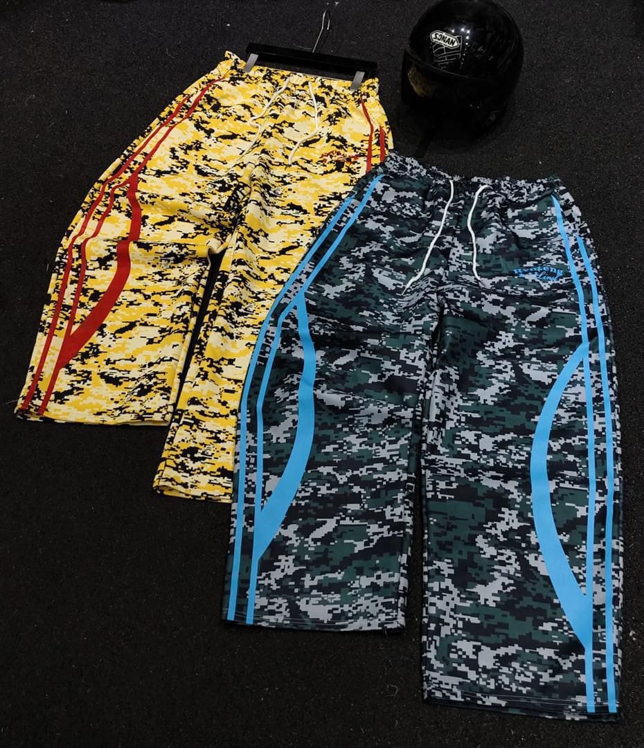 Yellow and green digital camouflage joggers with contrasting side stripes laid flat.