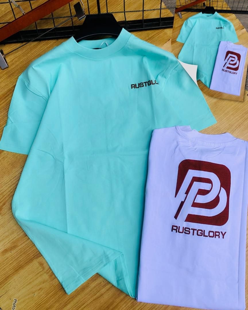 Mint green and purple Rustglory graphic t-shirts displayed together.